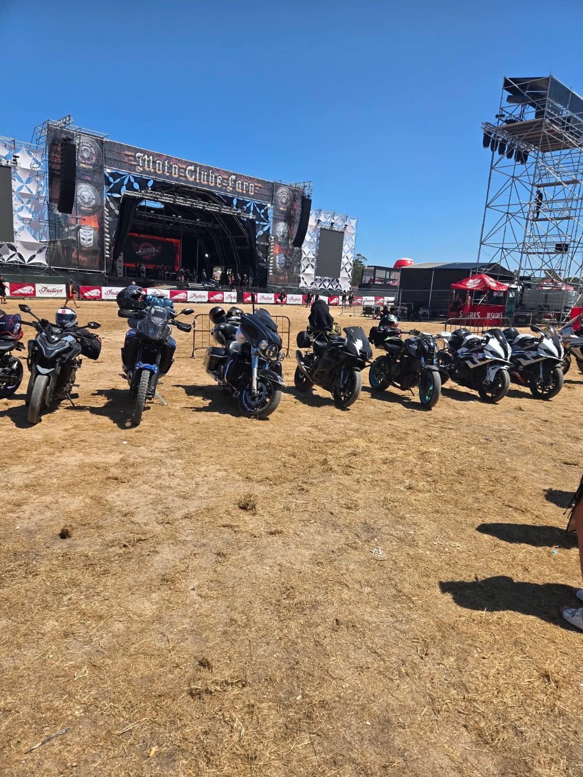 Motas alinhadas num recinto ao ar livre junto a um palco