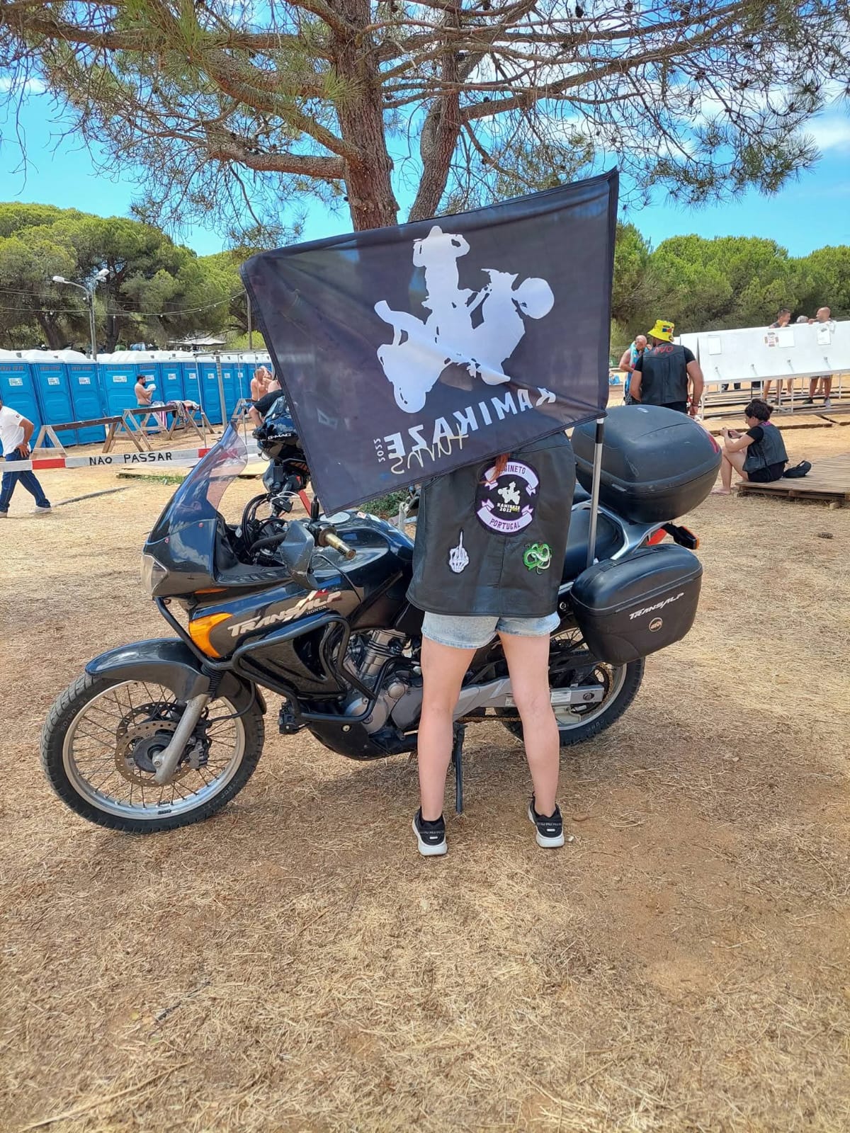 Membro do clube de costas, com a bandeira Kamikaze Turns presa à mota